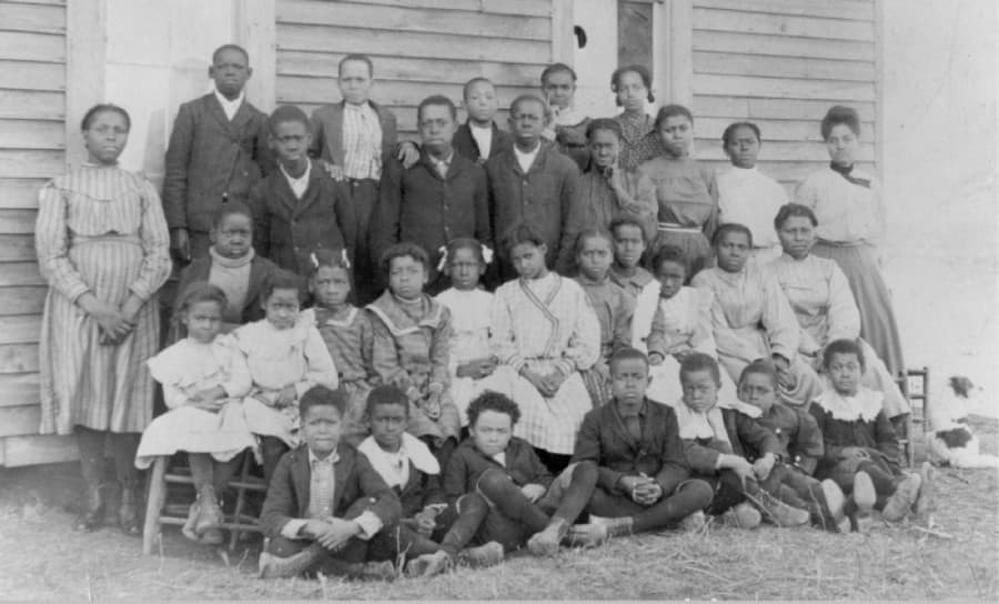 A group of children in early Plano gather outside of a school building in 1907. A segregated school was built in 1896, although classrooms would often travel around the community, according to library records. (Courtesy Plano Public Library)