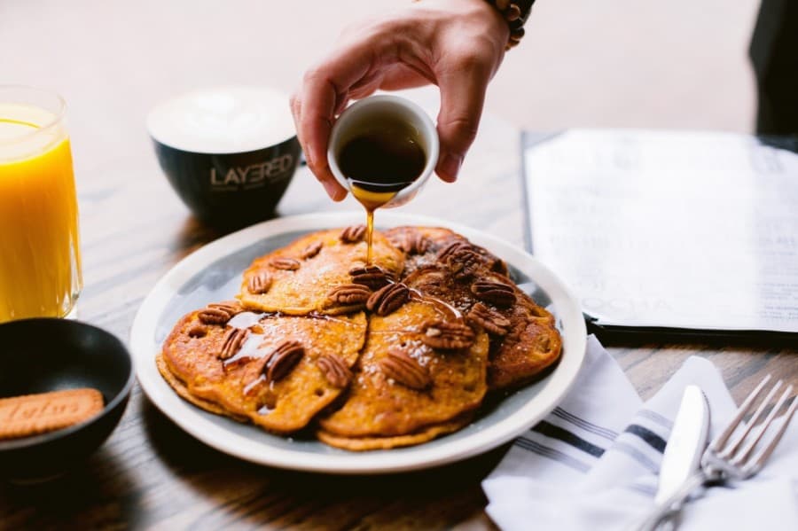 Sweet potato pancakes are crowned with syrup and pecans. (Courtesy Layered)