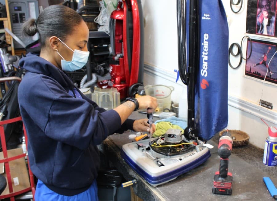 Woman works on vacuum.