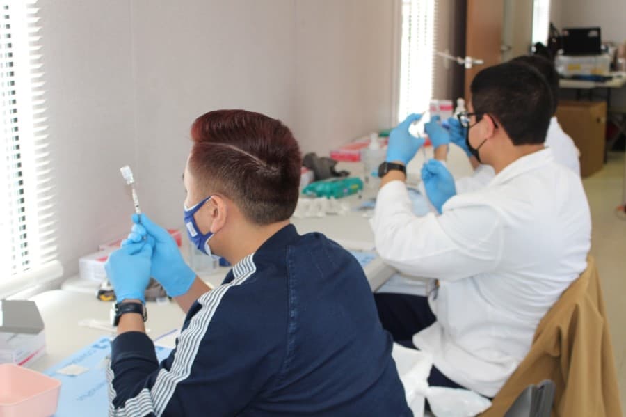 Physicians take the vaccine doses provided from the state and get them into syringes. (Andrew Christman/Community Impact Newspaper)