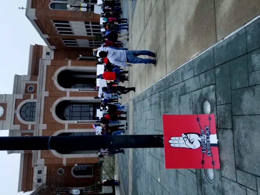 A pro-democracy sign leans against a pole near the site of a Feb. 27 protest at Lewisville City Hall. Protesters came out in opposition of the military coup in Myanmar that occurred earlier that month. (Aubrey Galloway/Community Impact Newspaper)