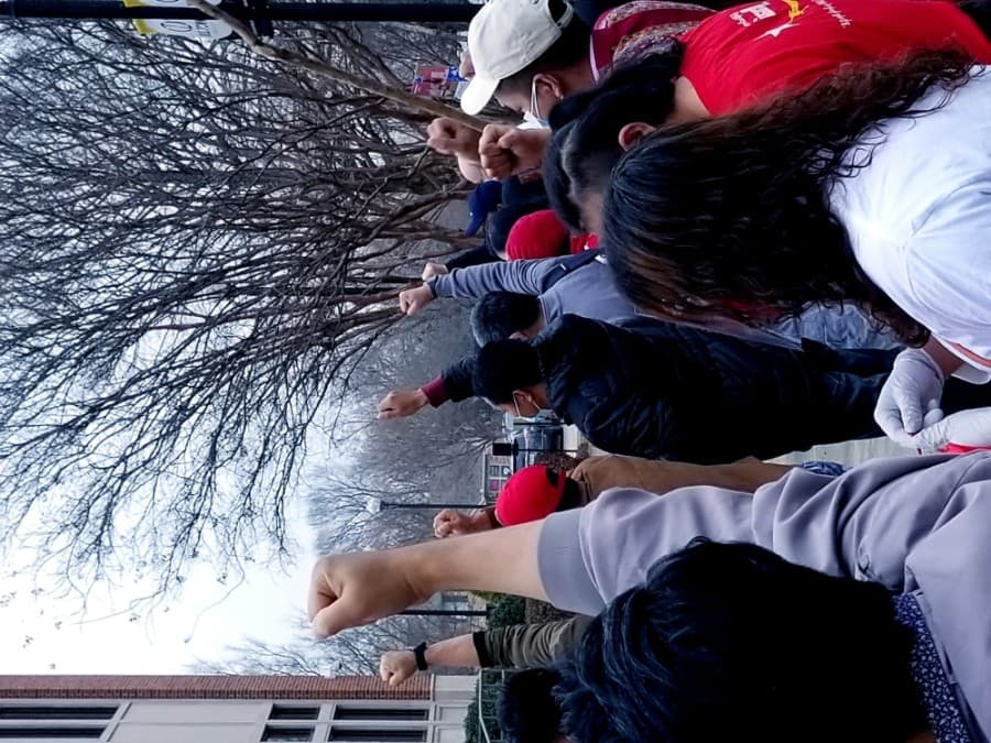 Protesters raise fists as part of a Feb. 27 protest of Myanmar's military arrests of civilian government leadership. The protest took place at Lewisville City Hall. (Aubrey Galloway/Community Impact Newspaper)