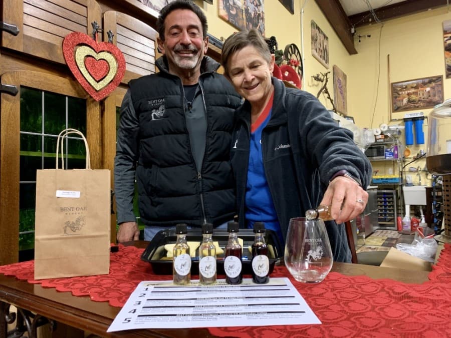 Bent Oak Winery CEO and winemaker John Catalano and Debbie Bruce, the winery's chief operating officer, offer a new Tasting to Go so customers can take home a flight of red and white wines. (Greg Perliski/Community Impact Newspaper)