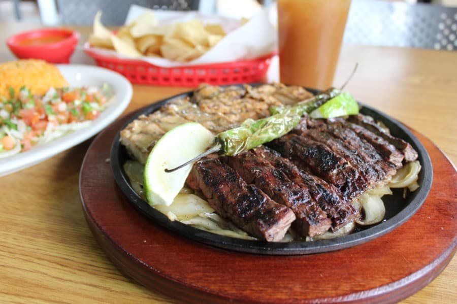 Beef and chicken fajitas ($17.99 for one, $35.99 for two): Grilled and served with fresh flour tortillas, rice, charro beans, pico de gallo and guacamole. (Shawn Arrajj/Community Impact Newspaper)