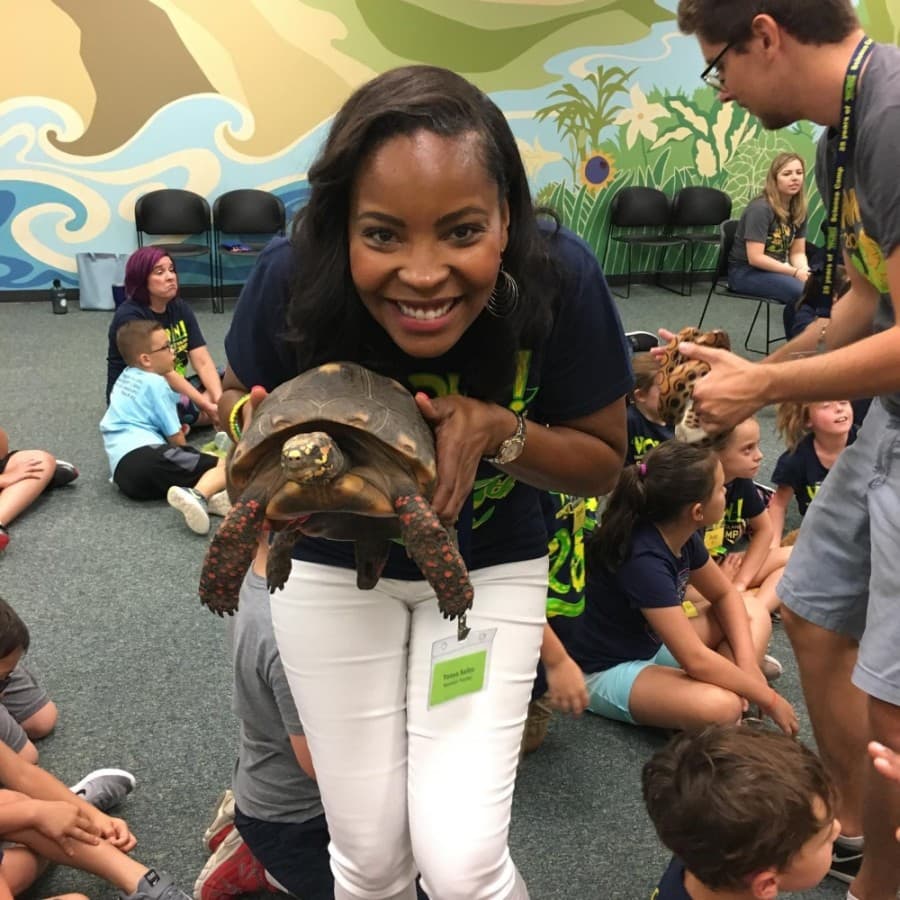 


Tonya Taylor, an assistant teacher at the camp, shares a tortoise with a group of students.