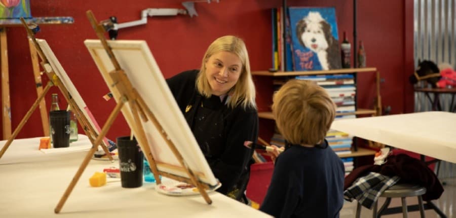 Skye Kennedy and 7-year-old Jillian Kennedy begin an Easter-themed painting during a free-paint session March 12. (Liesbeth Powers/Community Impact Newspaper)