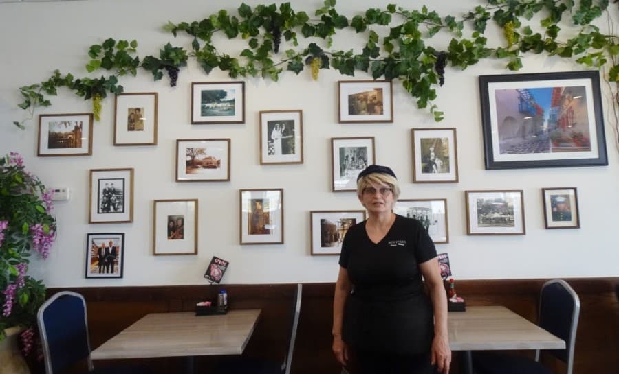 Maria Stefanakis (pictured) and Aristidis Varoutsos own and operate Athena's Greek & European Kitchen, a local restaurant they have designed to feel like home with their own family photos on the walls. (Danica Lloyd/Community Impact Newspaper)