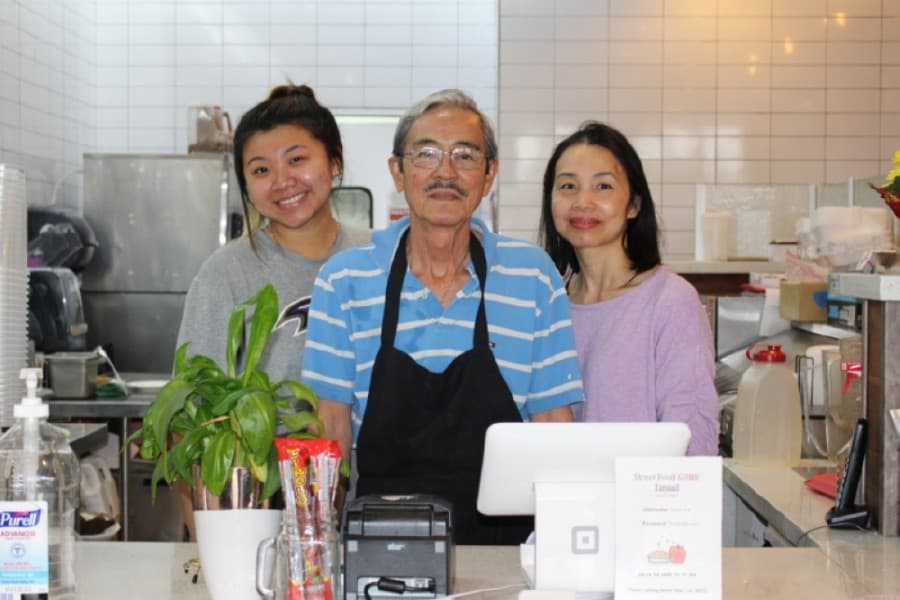 Hostess Olivia Lam (left) and chef Nhi Le (center) work at Street Food, owned by Sean Hoang and Huyen Le (right). (Adriana Rezal/Community Impact Newspaper)