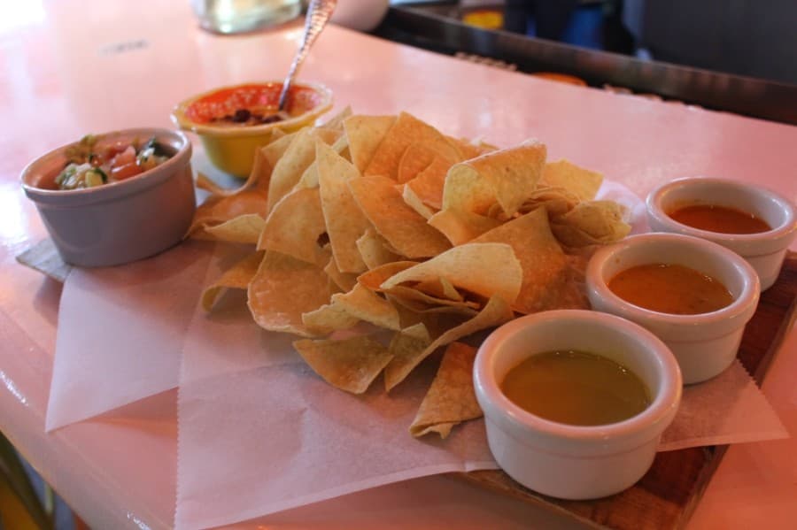 The Baja Fiesta Board ($15) offers three salsas, fresh guacamole and queso with chorizo. (Andrew Christman/Community Impact Newspaper)