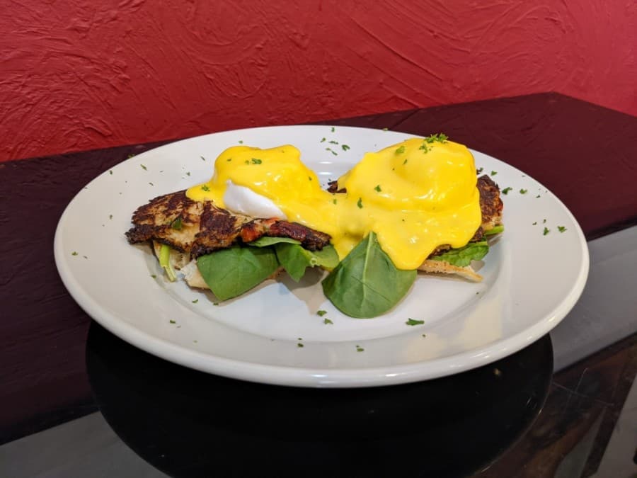 The Crab Cake Benedict includes two crab cakes on an English muffin and bed of spinach, topped with two poached eggs. (Photos by Jake Magee/Community Impact Newspaper)