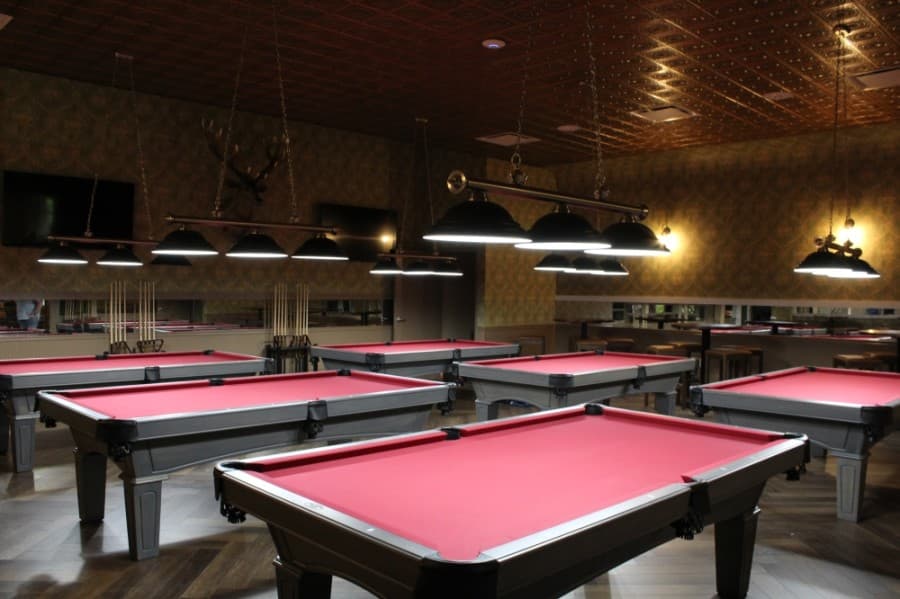 The billiards room in the REVL Social Club features six pool tables. (Megan Cardona/Community Impact Newspaper)