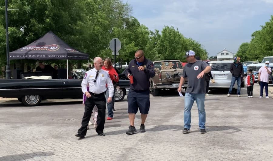Fire Chief Scott Kerwood dances the Cupid Shuffle at the intersection of Main Street and Farley Street. (Megan Cardona/Community Impact Newspaper)