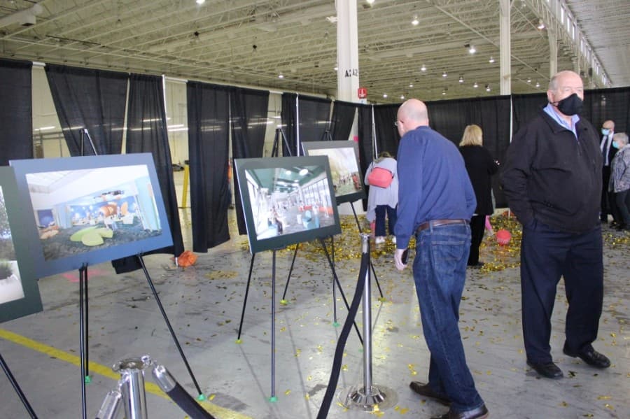 Attendees of the groundbreaking ceremony observe the renderings that show the new design for the library. (Miranda Jaimes/Community Impact Newspaper)