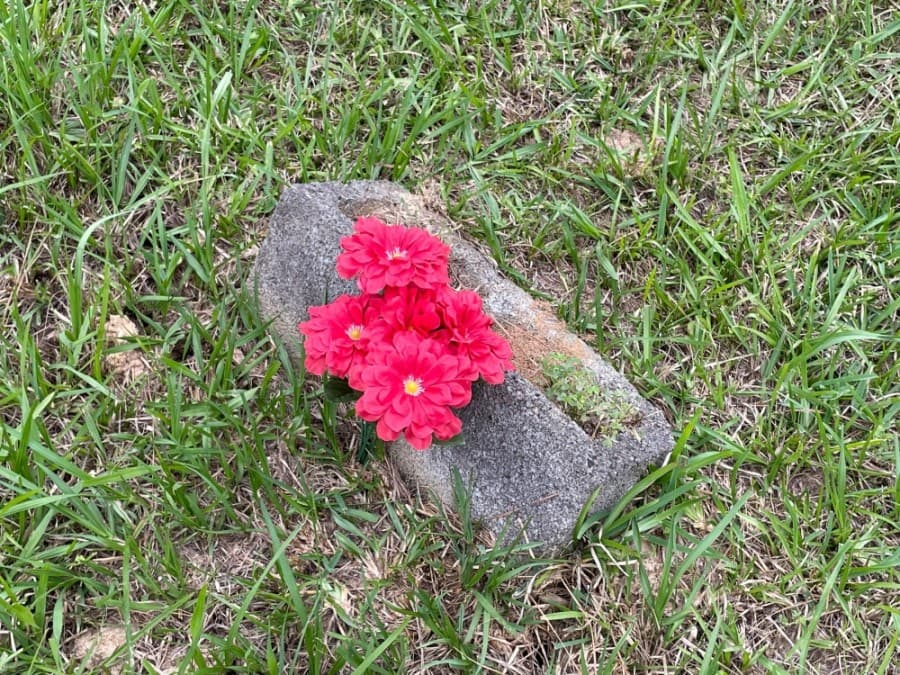 While some gravestones throughout the cemetery are more ornate, others are marked simply with a brick. (Hannah Zedaker/Community Impact Newspaper)