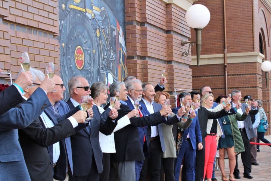 City council members, city staff and others raise their glasses and make a toast during the grand opening celebration of Grapevine Main Station. (Sandra Sadek/Community Impact Newspaper)