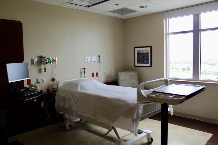 A hospital room with a bed and armchair