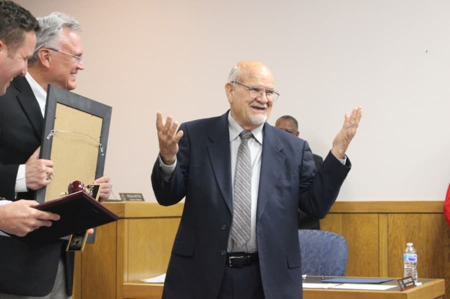 Former Mayor Merle Aaron (right) laughs with incoming Mayor Norman Funderburk (center) and City Manager Jason Stuebe (left) at his cracked gavel. (Kelly Schafler/Community Impact Newspaper)