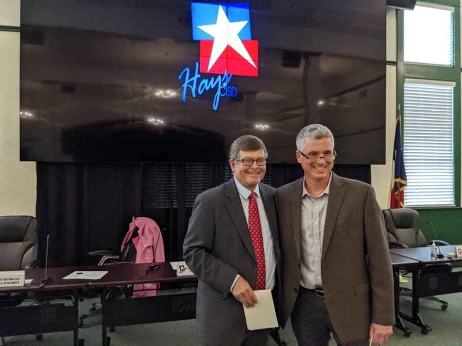 Hays CISD at-large trustee Will McManus (right) was sworn in for his second term by Hays County Precinct 2 Commissioner Mark Jones (left) during a May 17 meeting. (Warren Brown/Community Impact Newspaper)