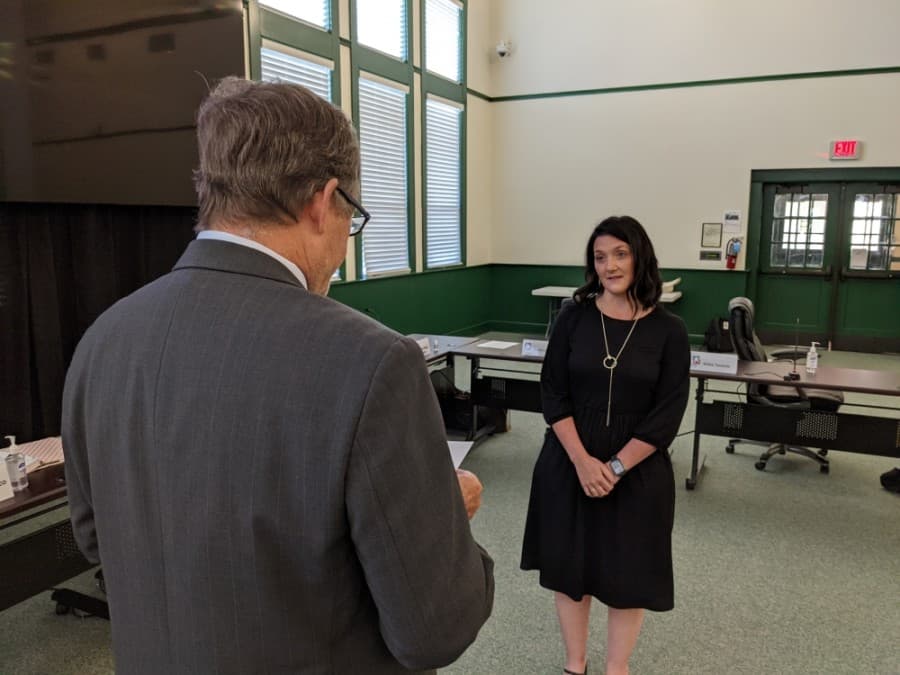 Hays County Precinct 2 Commissioner Mark Jones (left) swears in Hays CISD District 3 trustee Courtney Runkle (right) during a May 17 meeting. (Warren Brown/Community Impact Newspaper)