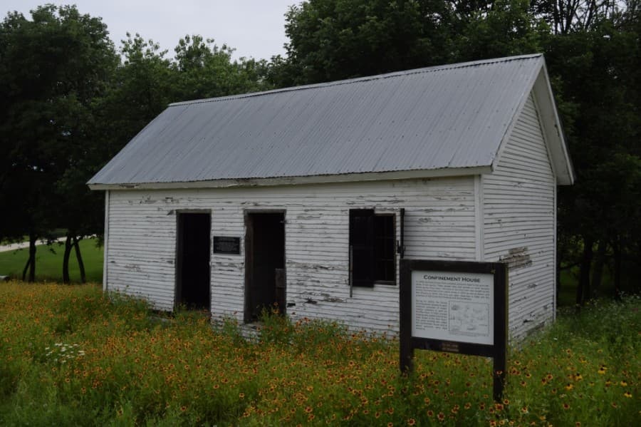 aged structure sits among wildflowers