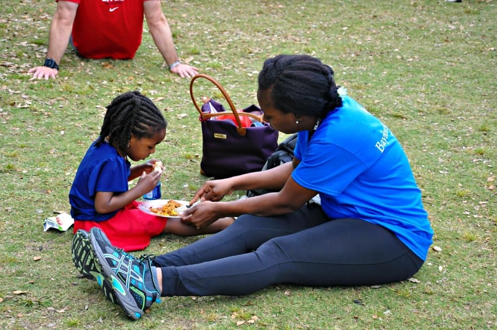 woman eating with child at the park