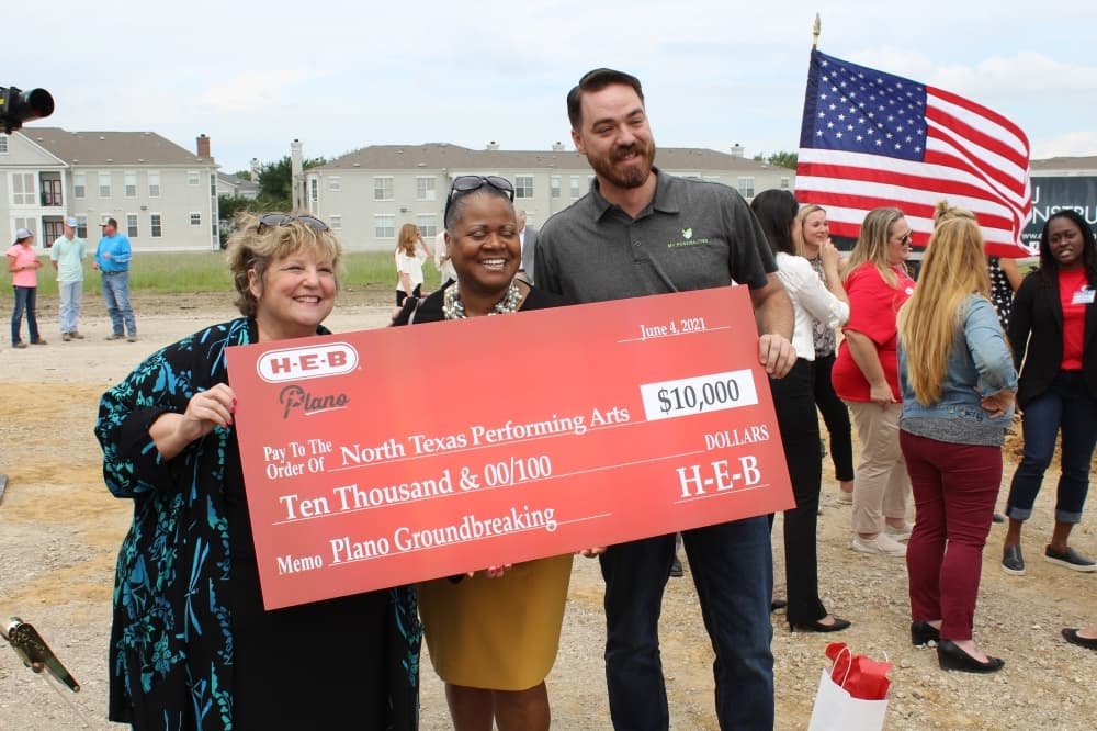 people posing with large check