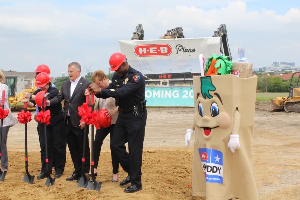people with shovels and a mascot