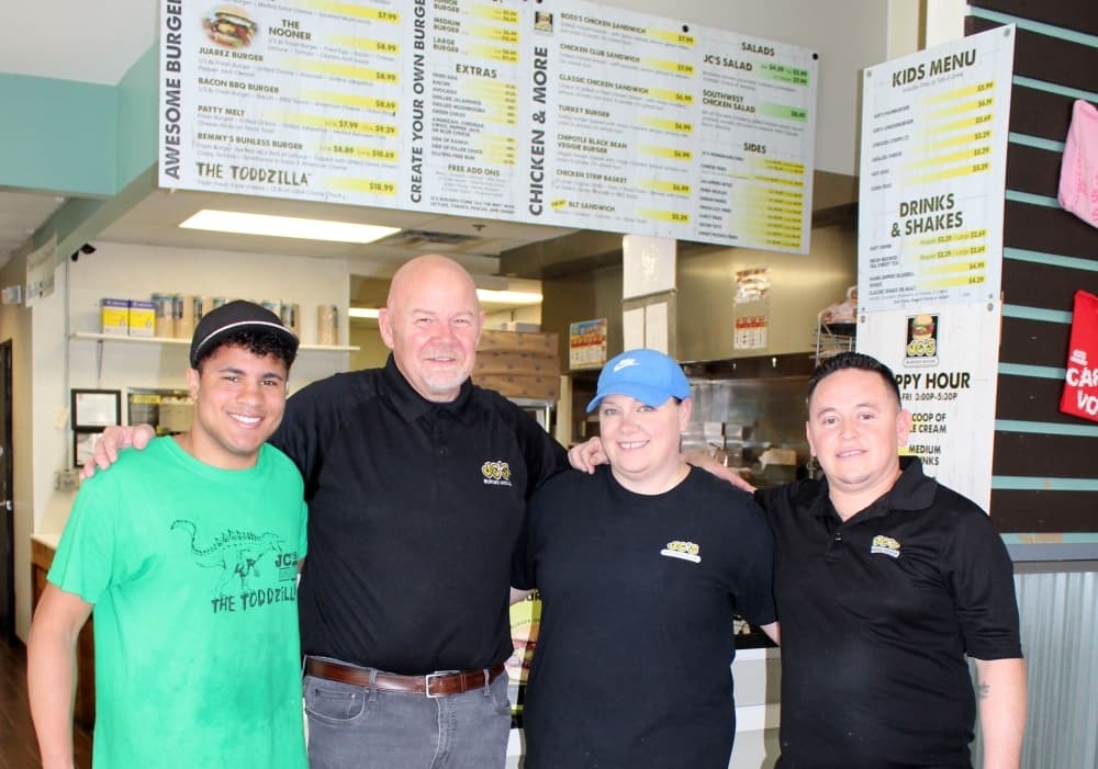 Bill Oglesby, second from left, with cashier/cook Shay Poulter (left) and store managers Amber and Jesus Zamora. The Zamoras met while working at JC’s Burger House. (Karen Chaney/Community Impact Newspaper)