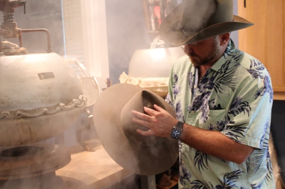 Jimmy Pierce shapes a hat for a rancher. (Megan Cardona/Community Impact Newspaper)
