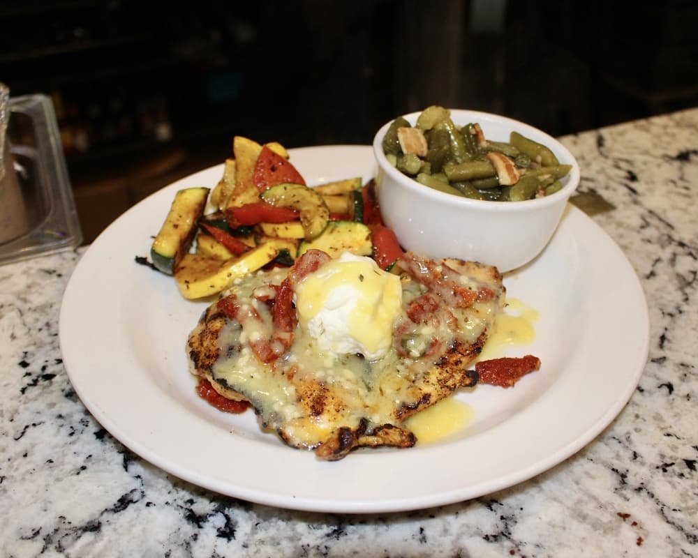 The Chicken Woodlands is a grilled chicken breast topped with goat cheese and sun-dried tomatoes. (Ally Bolender/Community Impact Newspaper)