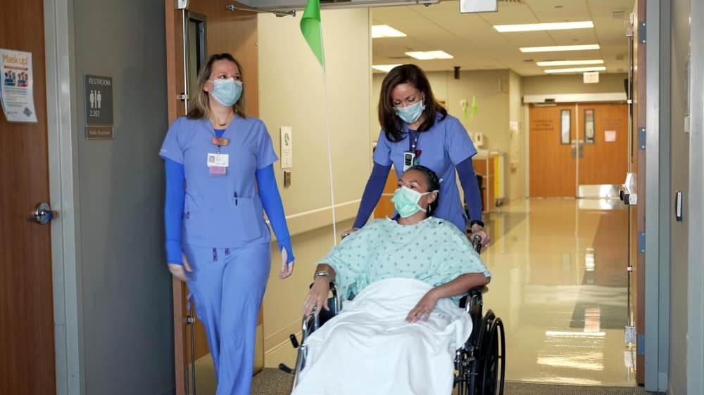 nurses wheeling a patient down the hall 