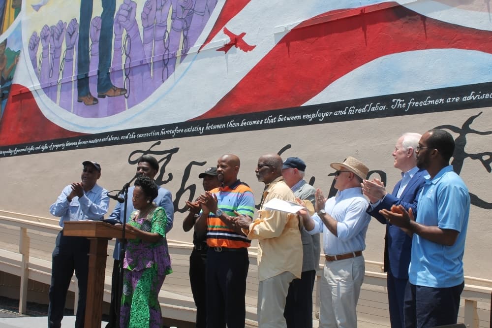 Sheila Jackson Lee (at podium) spoke at the event about the legislative process required to get Juneteenth designated as a federal holiday. John Cornyn (second from right) joined her in these efforts during the 87th legislative session. (Colleen Ferguson/Community Impact Newspaper)