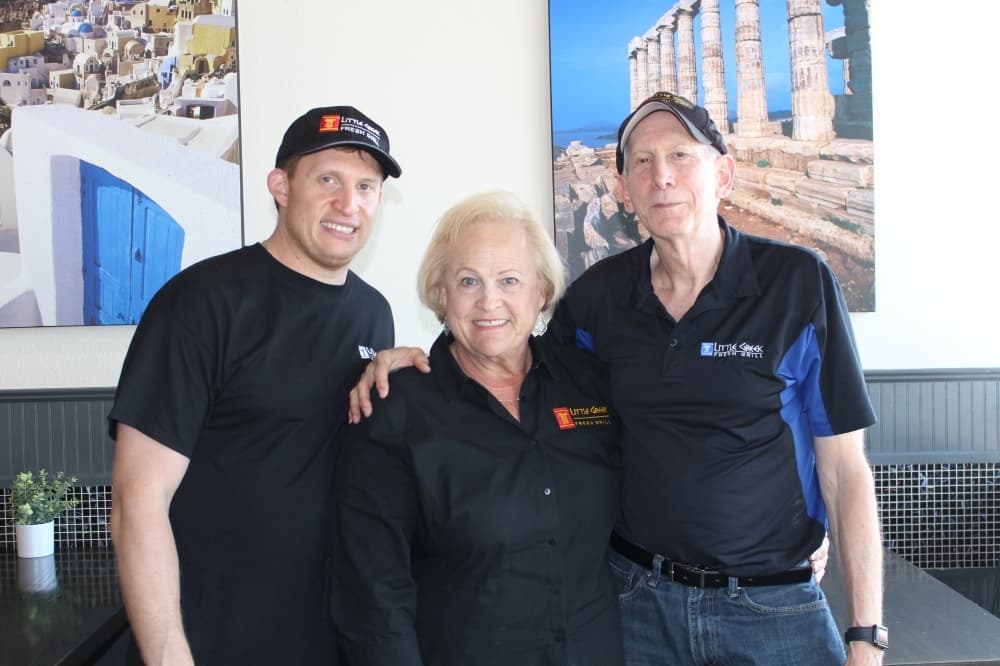Barry Rosen (right) and Jan Rosen (center) opened the first Little Greek Fresh Grill franchise in Richardson 11 years ago. Their son, Ryan (left), works with them at the restaurant. (Erick Pirayesh/Community Impact Newspaper)