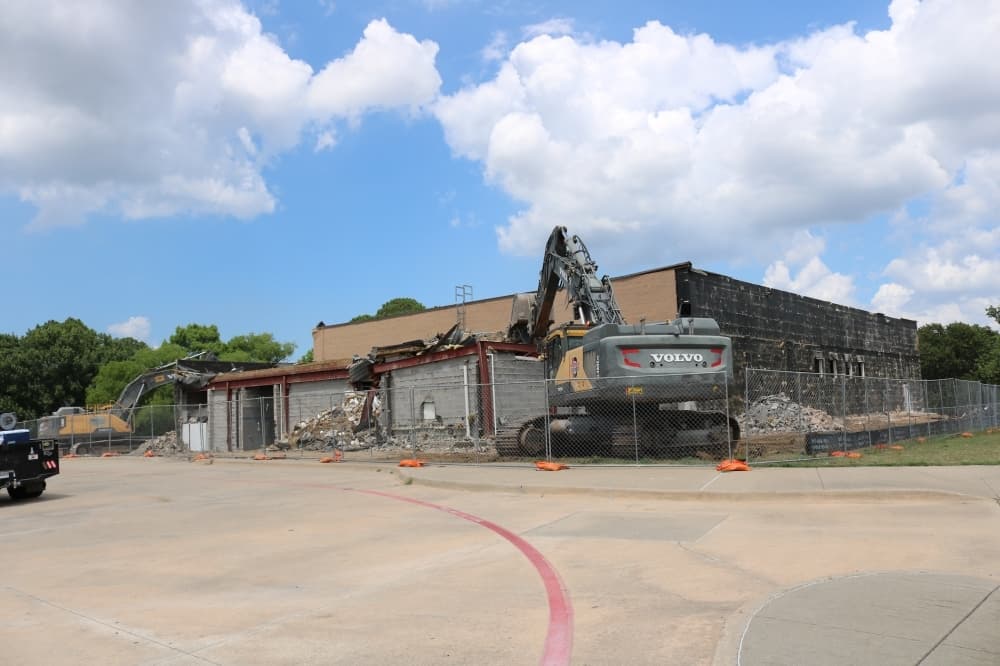 Crews are demolishing the former Lewisville ISD natatorium and communications building on Timber Creek Road in Flower Mound. (Kaushiki Roy/Community Impact Newspaper)