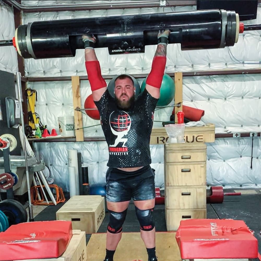 Richard Moczygemba, a champion strongman, practices the log press at the gym. (Lauren Canterberry/Community Impact Newspaper)