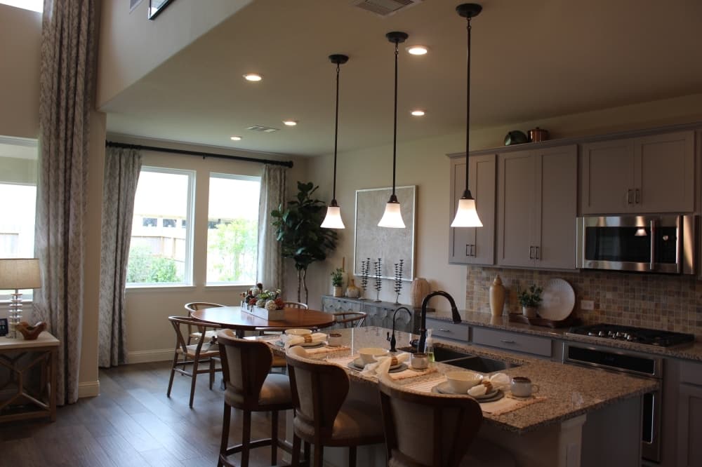 The dining room, kitchen and living room are connected in an open floor plan and feature high ceilings with plenty of natural light.