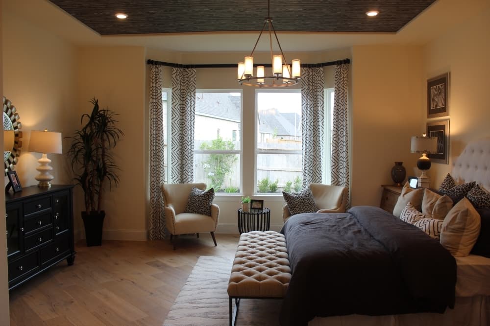 On the first floor, the primary bedroom has a windowed seating area with a view of the yard, and the room connects to a large bathroom.