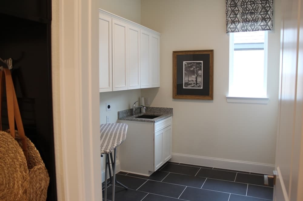 The utility room is just off the garage on the main floor and large enough for a washer, a dryer, a sink and an extra fridge.