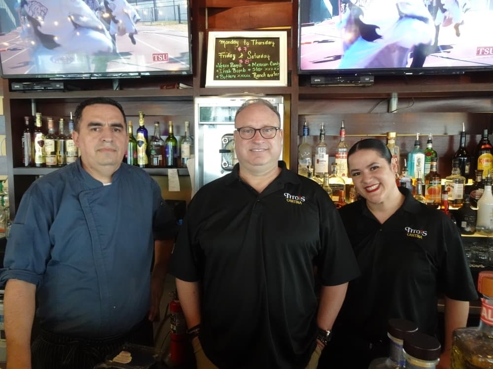 Joel Cecchetti (center) owns Tex-Mex eatery Tito's Cantina on Hwy. 290. He works alongside manager Michelle Rivera and chef Jorge Nava to create a welcoming atmosphere. (Emily Jaroszewski/Community Impact Newspaper)