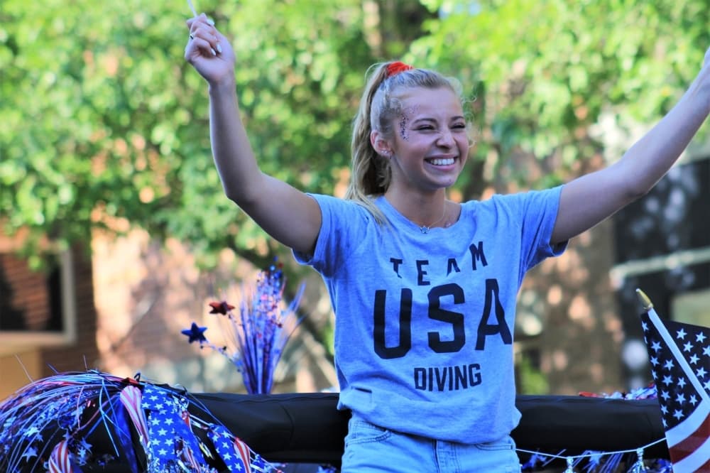 Hailey Hernandez, 18, waves U.S.A. flags during the parade. (Sandra Sadek/Community Impact Newspaper)