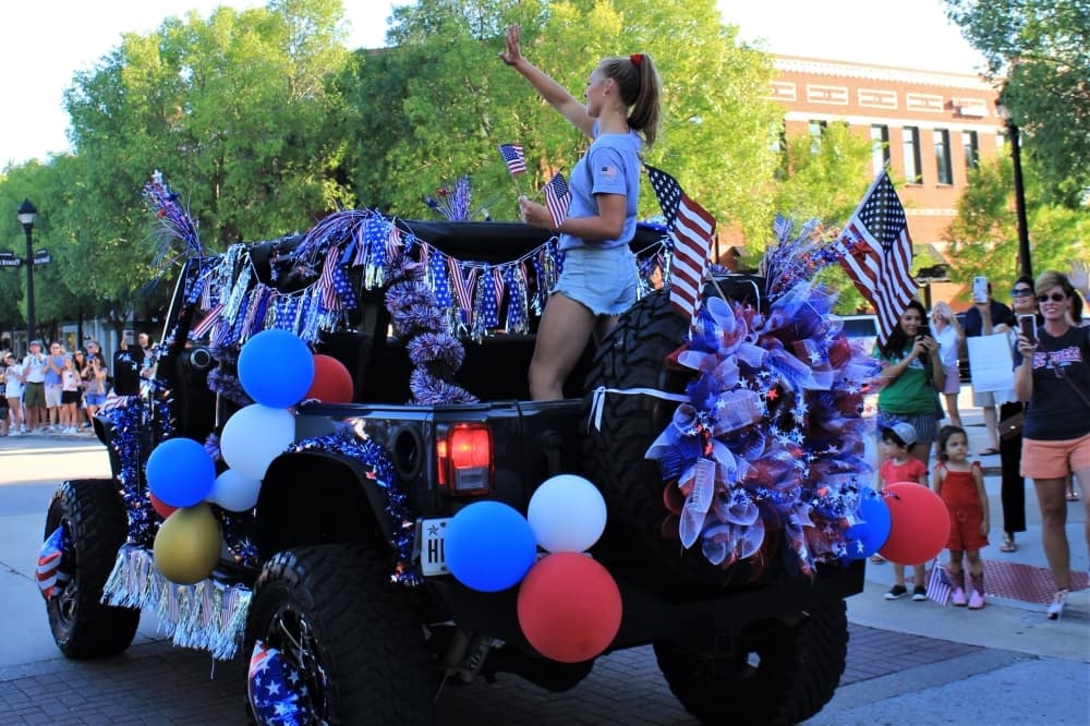 Hailey Hernandez, 18, waves at the crowd on July 9 in Town Square. (Sandra Sadek/Community Impact Newspaper)