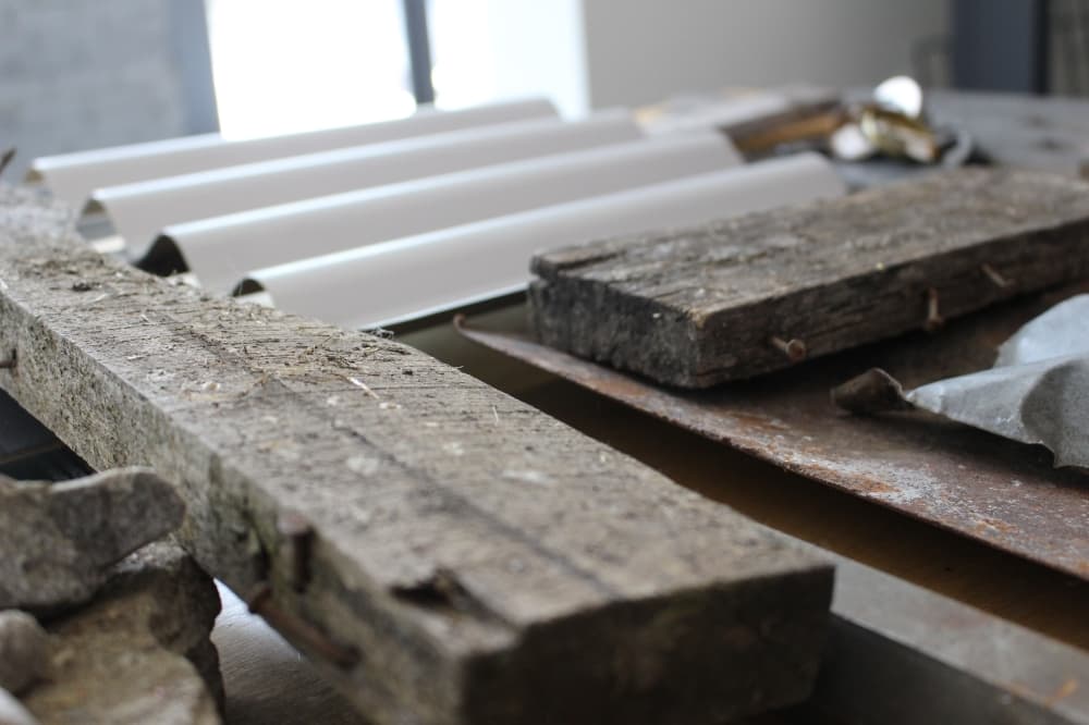 Wood and other objects from the new TUPPs Brewery site rest on a table at Conduit Architecture + Design in McKinney. Kobey Seale, co-owner of Conduit, said that recovering items from the construction site help architects "capture the feel" of the project. (Brooklynn Cooper/Community Impact Newspaper)