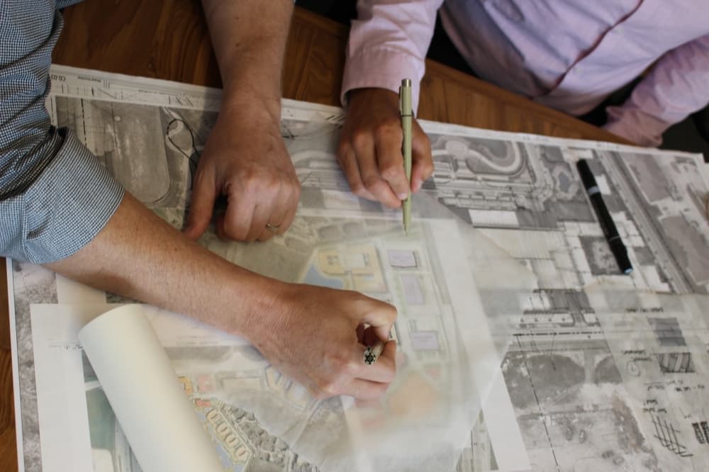 Kobey Seale (left) and Eric Ciskowski sketch a design in the conference room of Conduit Architecture and Design in McKinney. (Brooklynn Cooper/Community Impact Newspaper)
