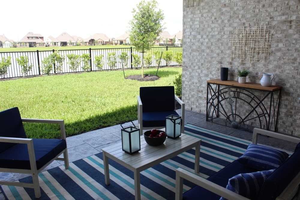 The covered patio with a lakefront view can be accessed through the game room or via the large sliding patio doors in the living room. (Savannah Kuchar/Community Impact Newspaper)