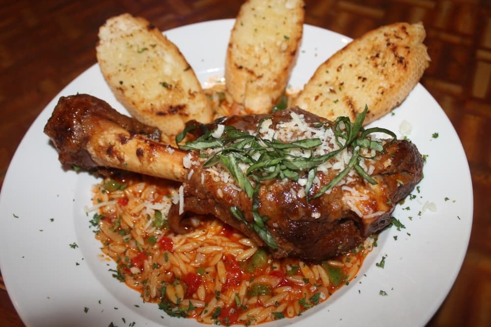 The lamb shank ($22) is braised in Greek herbs and spices and comes with beef orzo pasta and fresh bread. (Colleen Ferguson/Community Impact Newspaper)