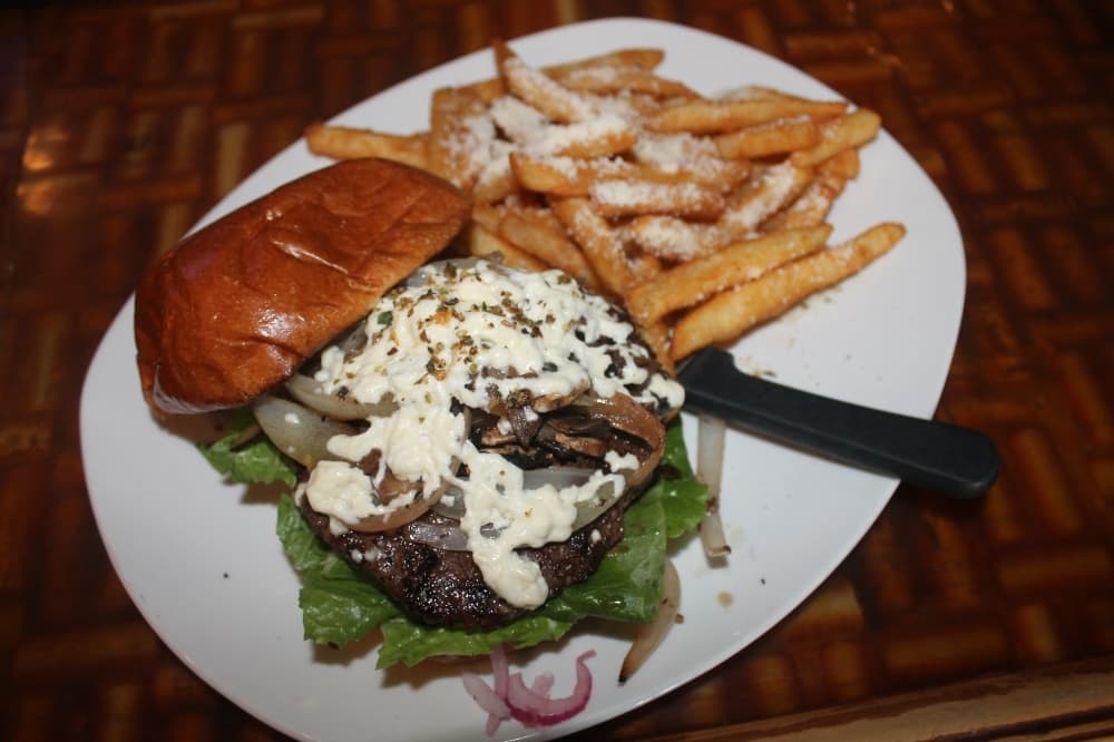 The $12 burger is marinated in red wine and topped with feta cheese, Greek spices, sauteed onions and mushrooms. (Colleen Ferguson/Community Impact Newspaper)