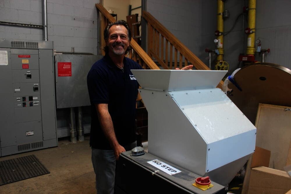 Photo of a man posting with aa plastic grinding machine