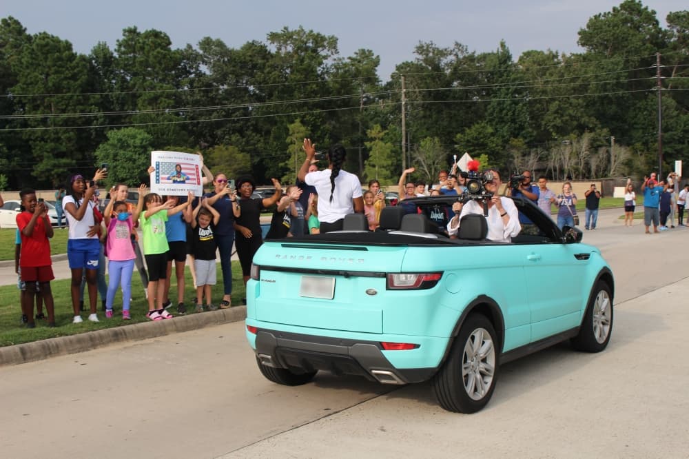 Biles waves to community members. (Ally Bolender/Community Impact Newspaper)