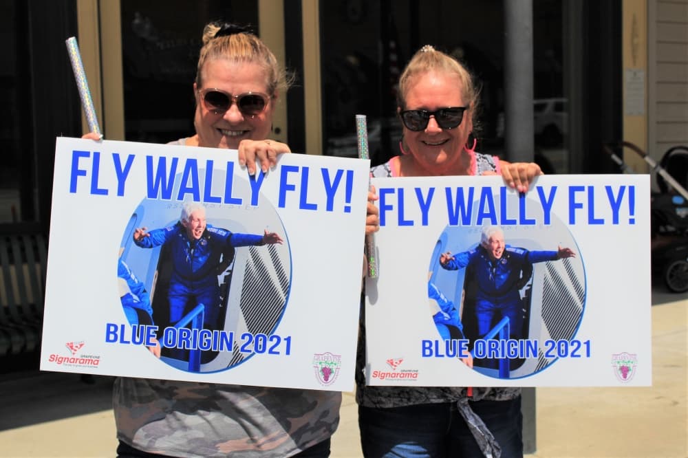 Best friends Pam Johnson (right) and Barbara Haas (left) brought signs to the parade. (Sandra Sadek/Community Impact Newspaper)