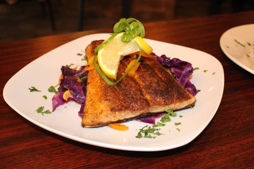 The chef special ($19.99) is blackened salmon on a bed of sauteed purple spinach with yellow squash and an orange bell pepper seared in white wine. (Ally Bolender/Community Impact Newspaper)